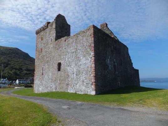 Lochranza Castle, an imposing old ruinous fortress, standing on a spit of land in a stunningly beautiful spot at Lochranza to the north of the mountainous island of Arran on the west coast of Scotland.