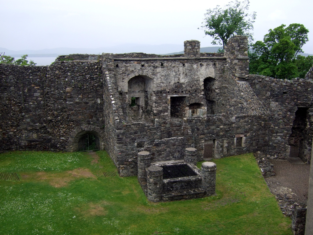 Courtyard buildings of Dunstaffnage Castle, an impressive but grim old ruinous walled castle, long held by the Campbells, with later tower and atmospheric chapel in a wooded spot near Oban in Argyll.