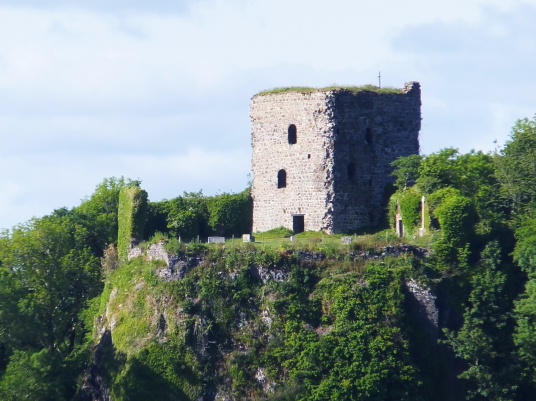 Dunollie Castle, an impressive ruinous tower on a prominent wooded spot above the later Dunollie House, long held by the MacDougalls, now with a museum, and near the seaside town of Oban in Argyll on the west coast of Scotland.