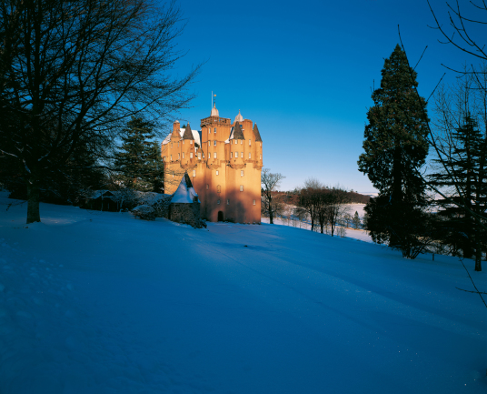 Craigievar Castle by Tom Wolf, a magnificent and imposing old tower house with a fantastic atmospheric and period interior, long held by the powerful Forbes family and set in beautiful wooded grounds in the rolling hills of Aberdeenshire near Alford in no