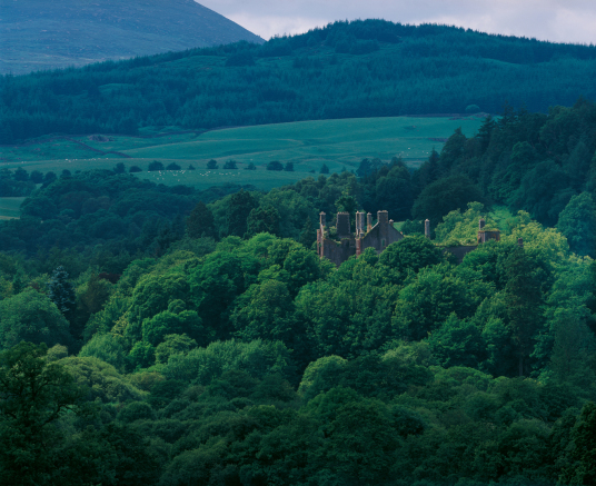 Kenmure Castle, a large overgrown ruin of a once splendid old stronghold and sumptuous mansion, long held by the Gordons of Kenmure and in a wooded spot near New Galloway in southwest Scotland.