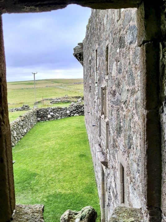 Muness Castle is the most northerly castle in Britain, and is a fine impressive ruin in a quiet and lonely spot on the island of Unst in the Shetland islands in the far north of Scotland, once home to the Bruces, incomers to Shetland.